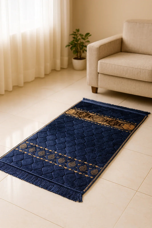 Navy blue Islamic prayer mat with gold patterns on tiled floor near beige couch and potted plant