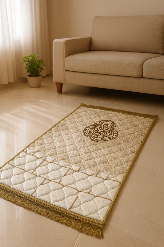 Beige Islamic prayer mat with ornate central design on tiled floor near a beige sofa and green potted plant