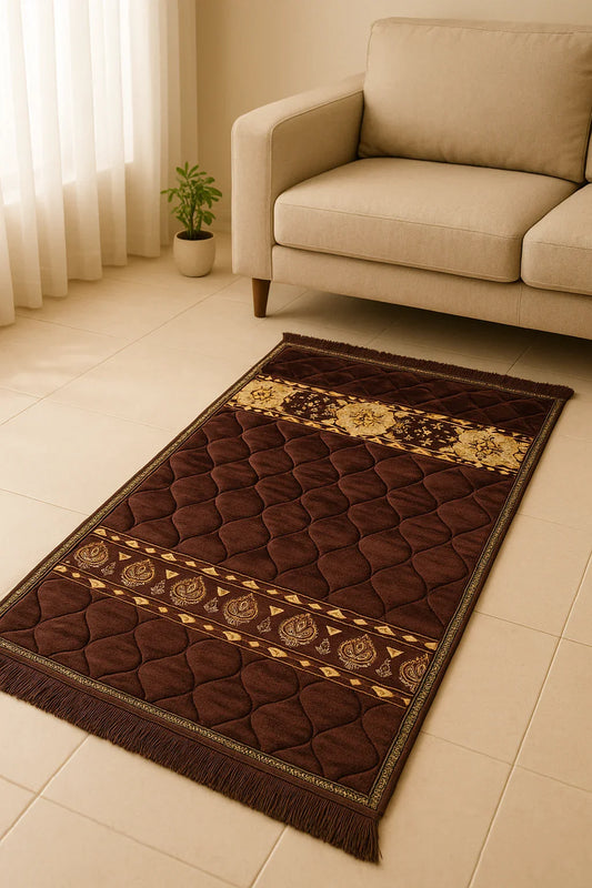 Brown Islamic prayer mat with gold floral patterns placed on beige tiled floor near beige sofa and small potted plant