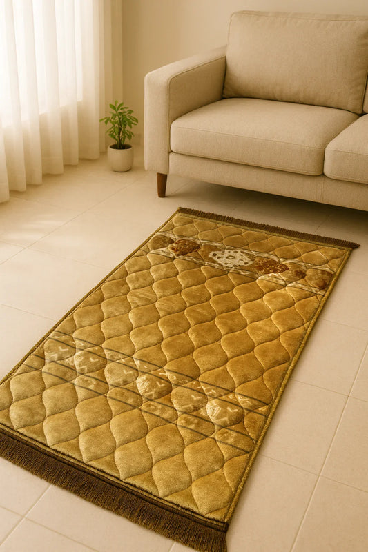 golden quilted Islamic prayer mat with intricate design next to beige sofa and potted plant