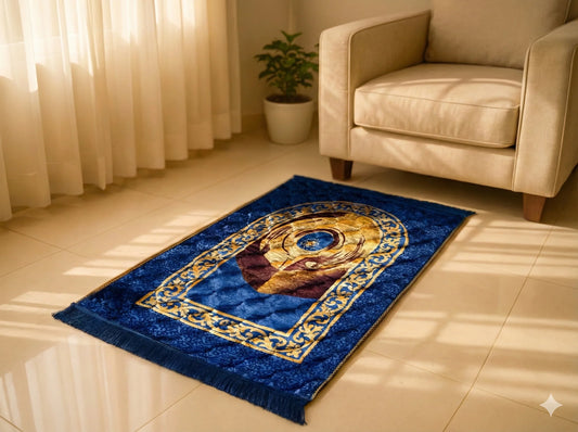 Blue Islamic prayer mat with gold and brown circular design on tiled floor near beige armchair and potted plant