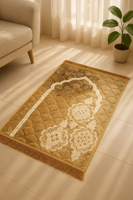 Luxury beige velvet Islamic prayer mat with floral arch design placed on tiled floor near beige sofa and potted plant