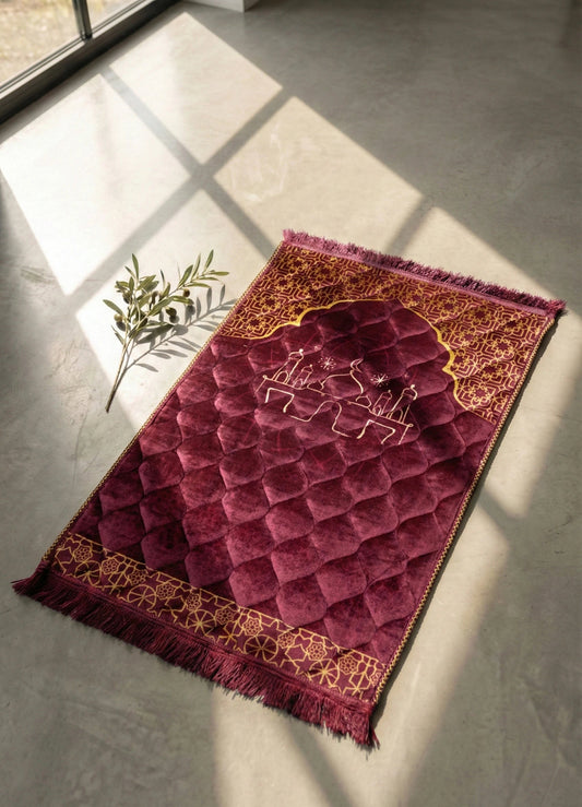 Maroon islamic prayer mat & Jay Namaz with intricate patterns on a gray floor.