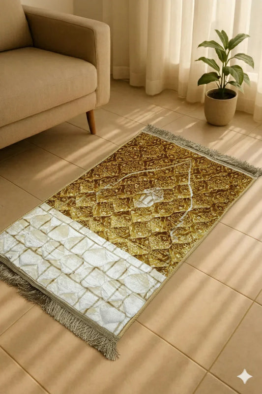 Elegant Islamic prayer mat in beige and gold with intricate designs, placed on tiled floor near beige sofa and potted plant
