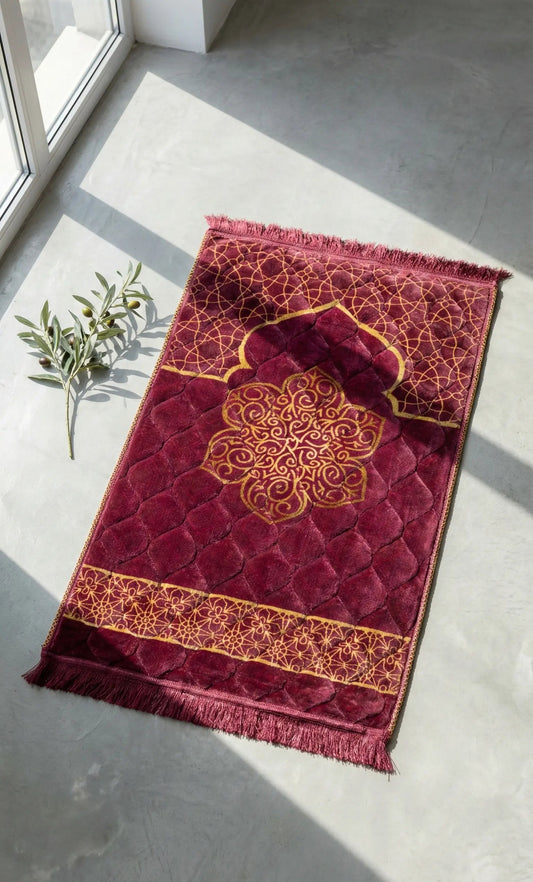 Red islamic jay namaz prayer mat with gold patterns on a light gray floor.