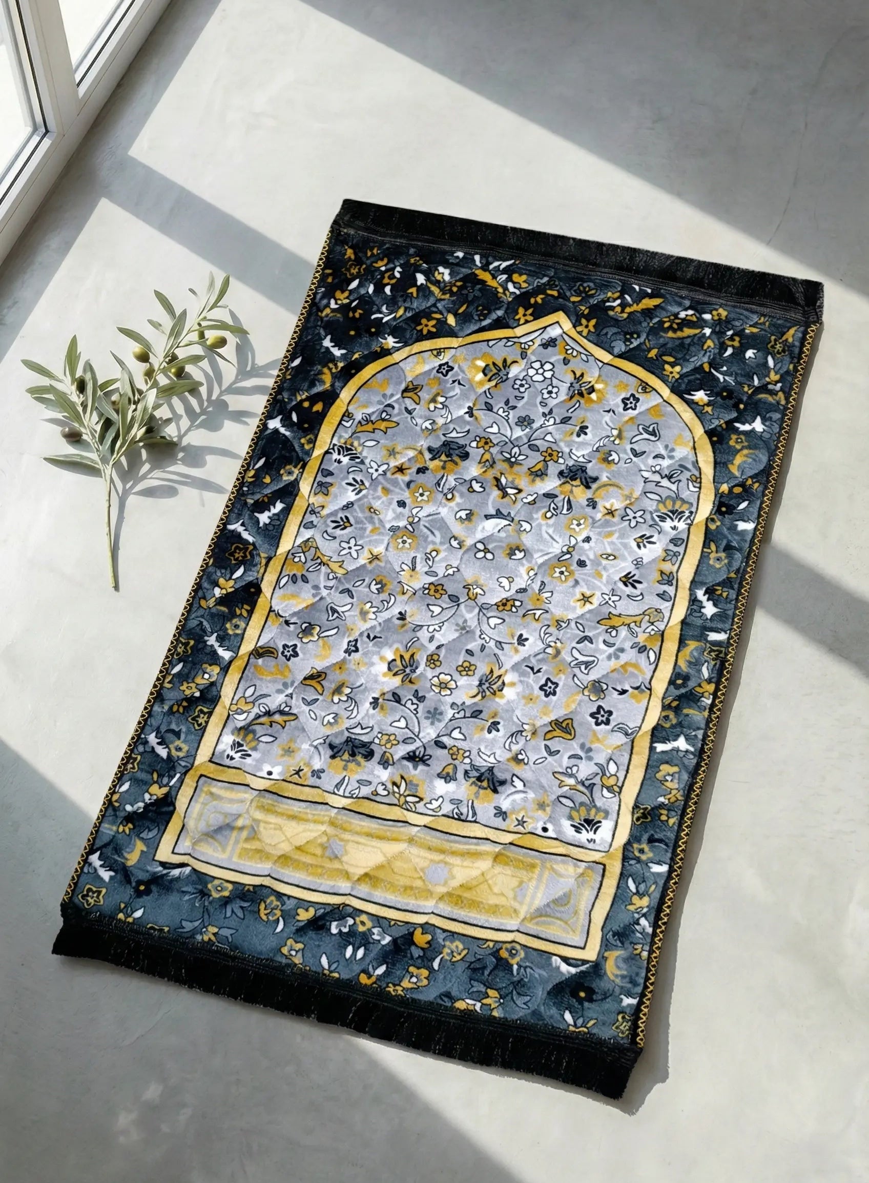 soft velvet prayer mat in pakistan  with intricate design on a light gray floor.